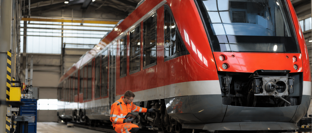 Techniker prüft einen Dieseltriebzug in einer Werkhalle während der Instandhaltung im Schienenpersonennahverkehr.